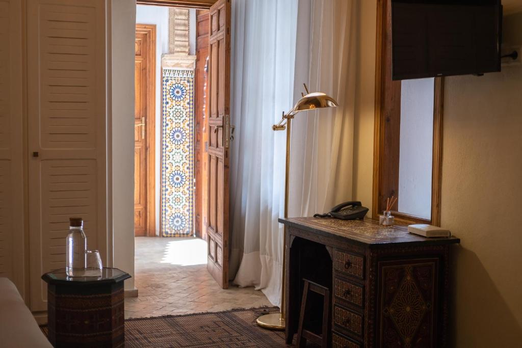 Cette chambre dispose d'un couloir avec une porte ouverte et un téléphone. dans l'établissement Dar Shâan, à Rabat