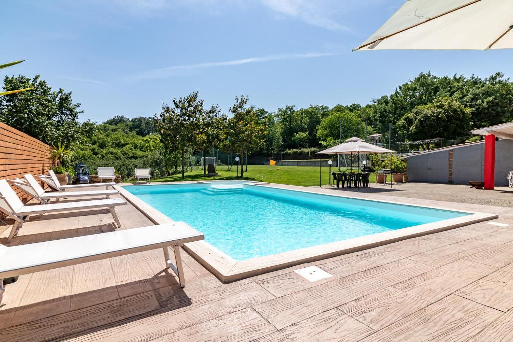 une piscine avec deux chaises et une table dans l'établissement Villa Vacanze La Quercia, à Carbognano