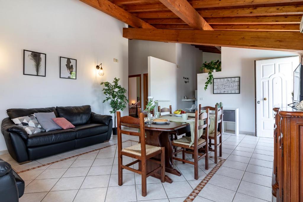 un salon avec une table, des chaises et un canapé dans l'établissement Villa Vacanze La Quercia, à Carbognano