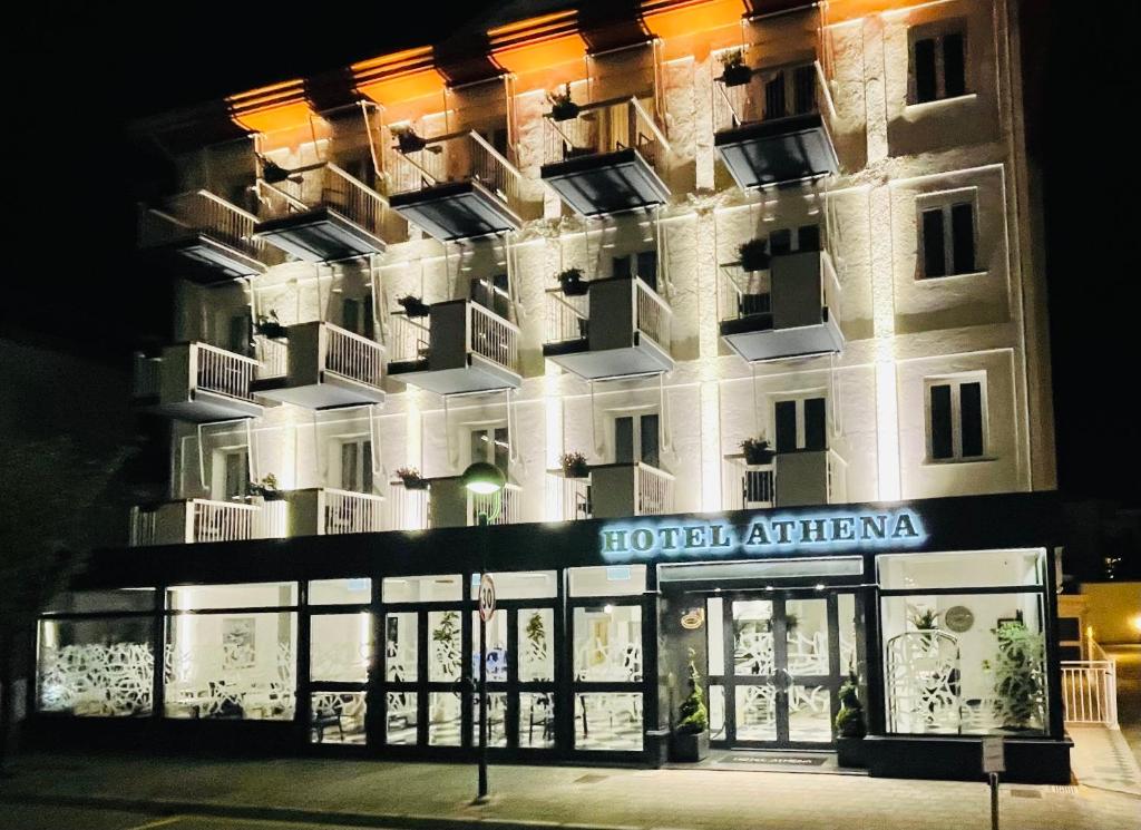 un hôtel la nuit avec des lumières sur la façade dans l'établissement Hotel Athena, à Lignano Sabbiadoro 21 autres photos