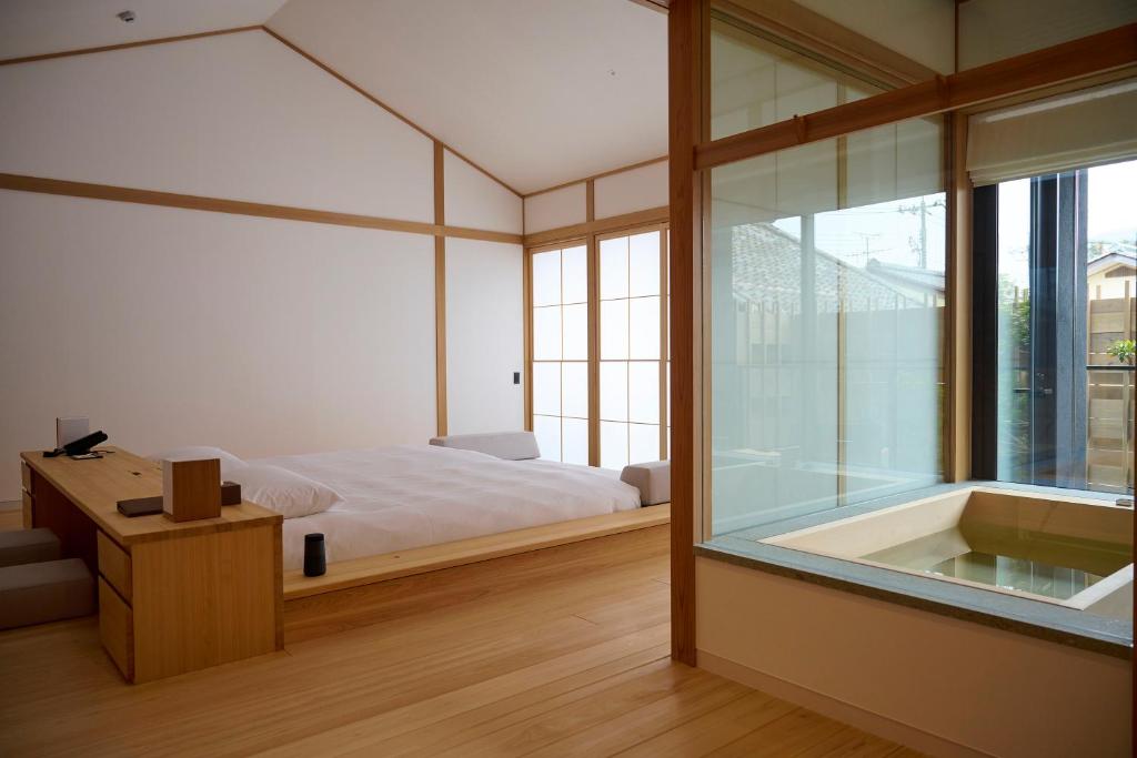 - une chambre avec un lit et une baignoire à côté d'une fenêtre dans l'établissement Azumi Setoda, à Onomichi