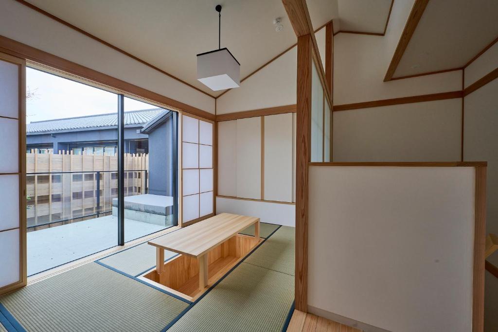 une pièce vide avec un banc et une grande fenêtre dans l'établissement Azumi Setoda, à Onomichi