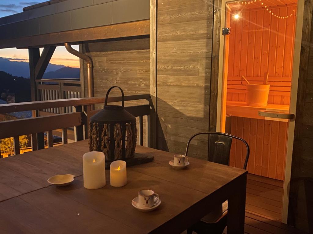 - une table en bois avec deux bougies sur le balcon dans l'établissement Penthouse l'Ourse Bleue - Sauna privatif - accès direct aux pistes, à Courchevel