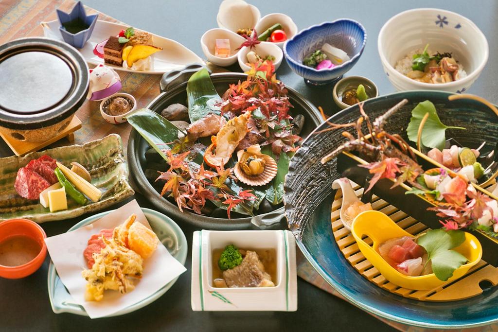 une table avec de nombreuses assiettes de nourriture dessus dans l'établissement Genjiko, à Minamichita 37 autres photos