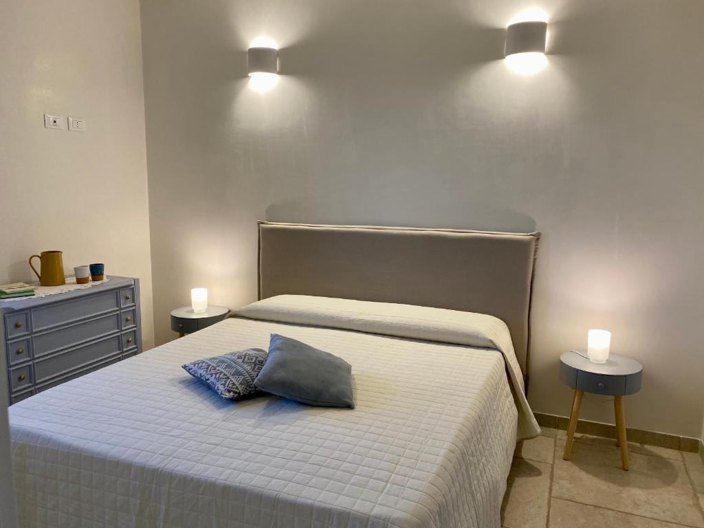 une chambre avec un lit avec un oreiller bleu dessus dans l'établissement MASSERIA FRANTELLA, à Grottaglie