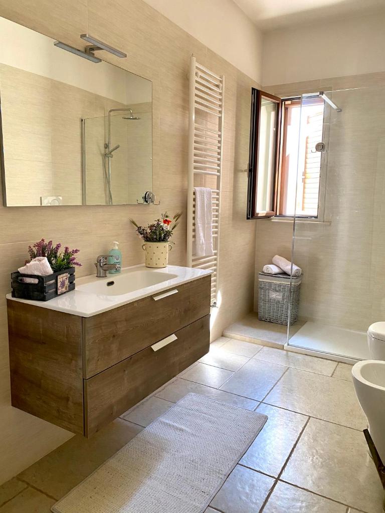 une salle de bain avec un lavabo, un miroir et une baignoire dans l'établissement MASSERIA FRANTELLA, à Grottaglie