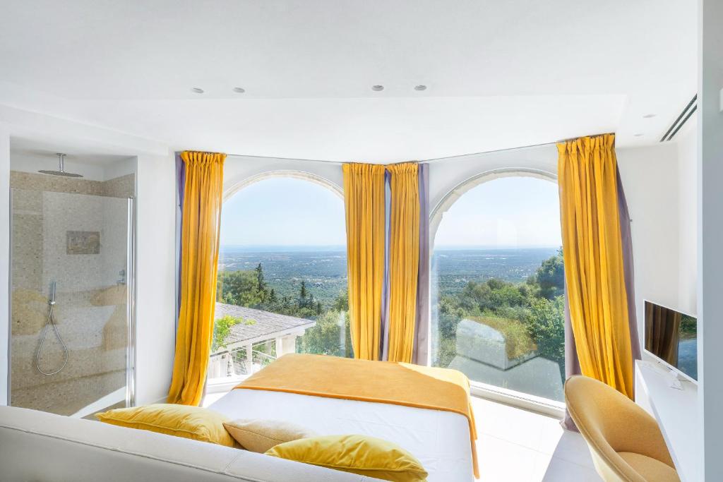 une chambre avec un lit et une grande fenêtre dans l'établissement Villa Lemorè, à Fasano