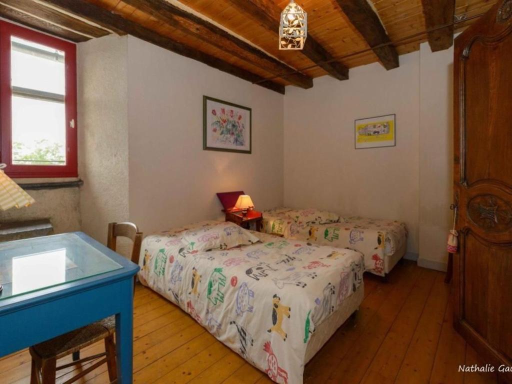 - une chambre avec 2 lits et une table bleue dans l'établissement Maison spacieuse avec piscine chauffée, jardin clos et équipements de loisirs en pleine campagne - FR-1-306-1114, à Pannecé