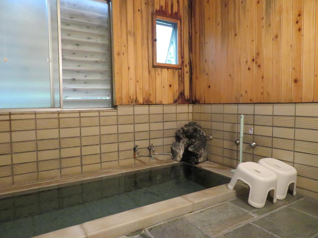 La salle de bains est pourvue d'une baignoire et de toilettes. dans l'établissement Hakone Miyanoshita Myojokan, à Hakone