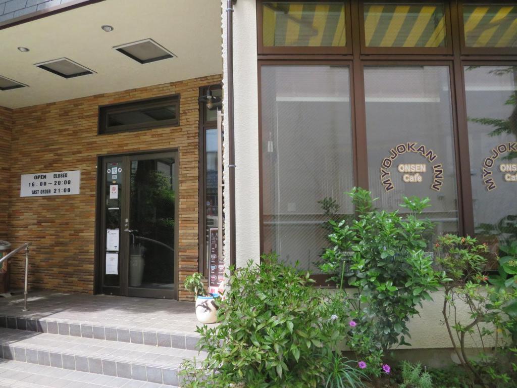une porte d'entrée d'un restaurant avec des plantes devant dans l'établissement Hakone Miyanoshita Myojokan, à Hakone 37 autres photos