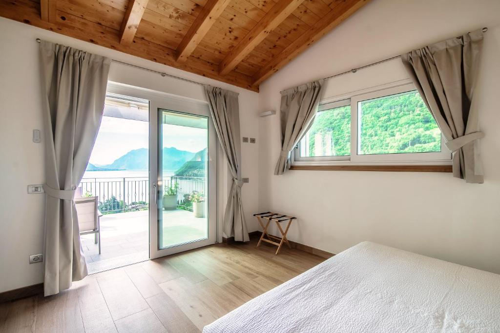 une chambre avec un lit et une grande fenêtre dans l'établissement Villa Breva - Bellagio, à Bellagio