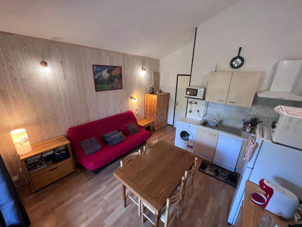 un salon avec un canapé rouge et une table dans l'établissement Résidence les Cristallines, à Le Lioran