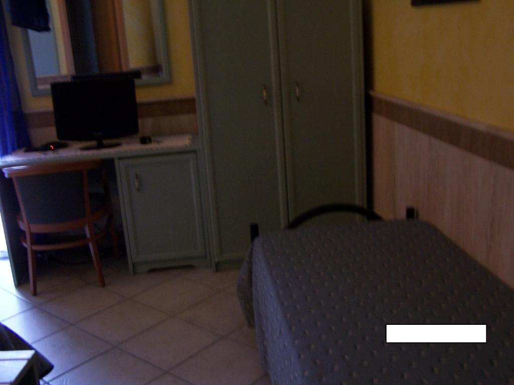 une chambre avec un lit et un bureau avec un ordinateur dans l'établissement Hotel Nautilus, à Nicotera Marina