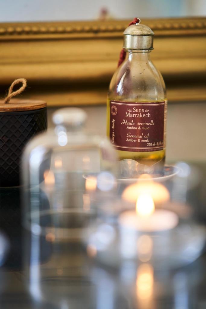 une bouteille d'huile assise sur une table avec une bougie dans l'établissement Riad Rafaele & SPA, à Marrakech