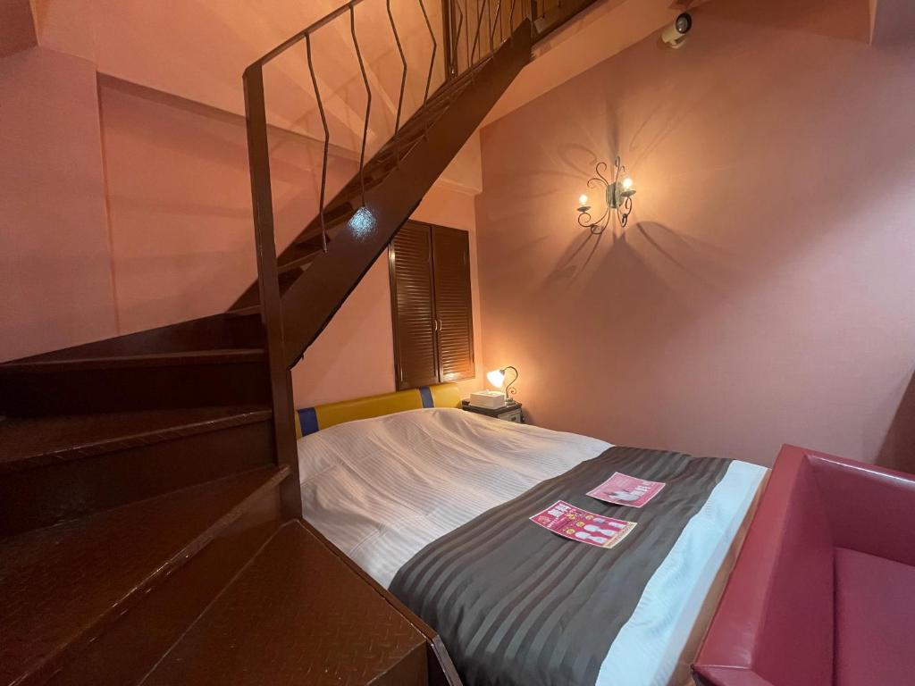 une chambre avec un lit superposé avec un escalier dans l'établissement HOTEL マナティ, à Akashi