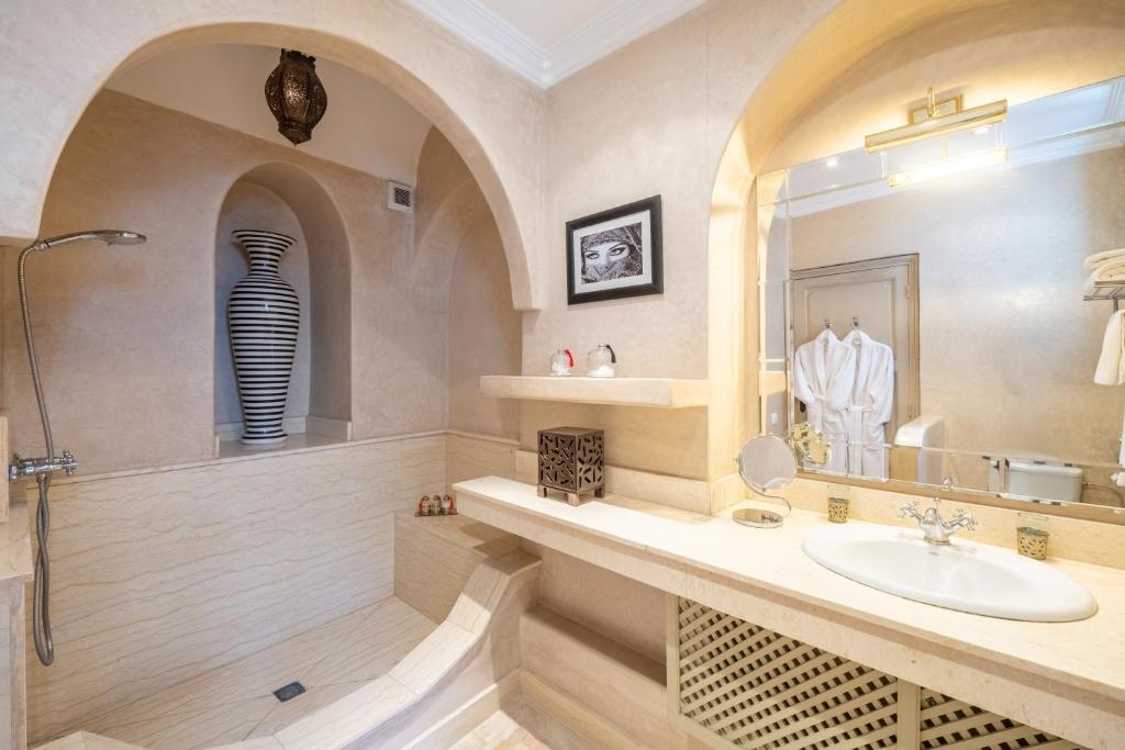 une salle de bain avec un lavabo et un miroir dans l'établissement Riad Alma, à Marrakech