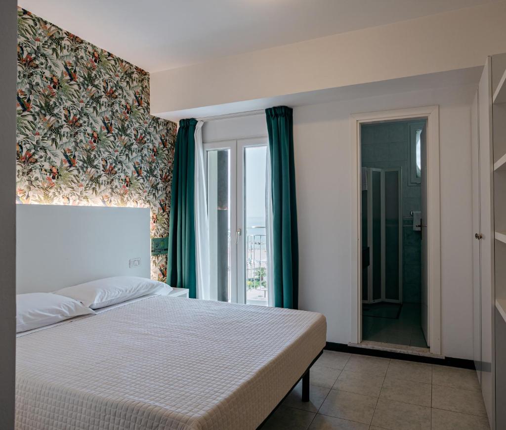 une chambre avec un grand lit et une fenêtre dans l'établissement SoleMare Hotel e Residence, à Misano Adriatico