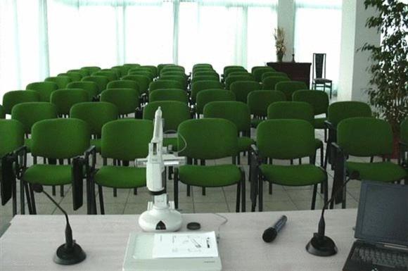 une salle de conférence avec des chaises vertes et un ordinateur portable sur une table dans l'établissement Hotel Haus Charlotte, à San Benedetto del Tronto 48 autres photos