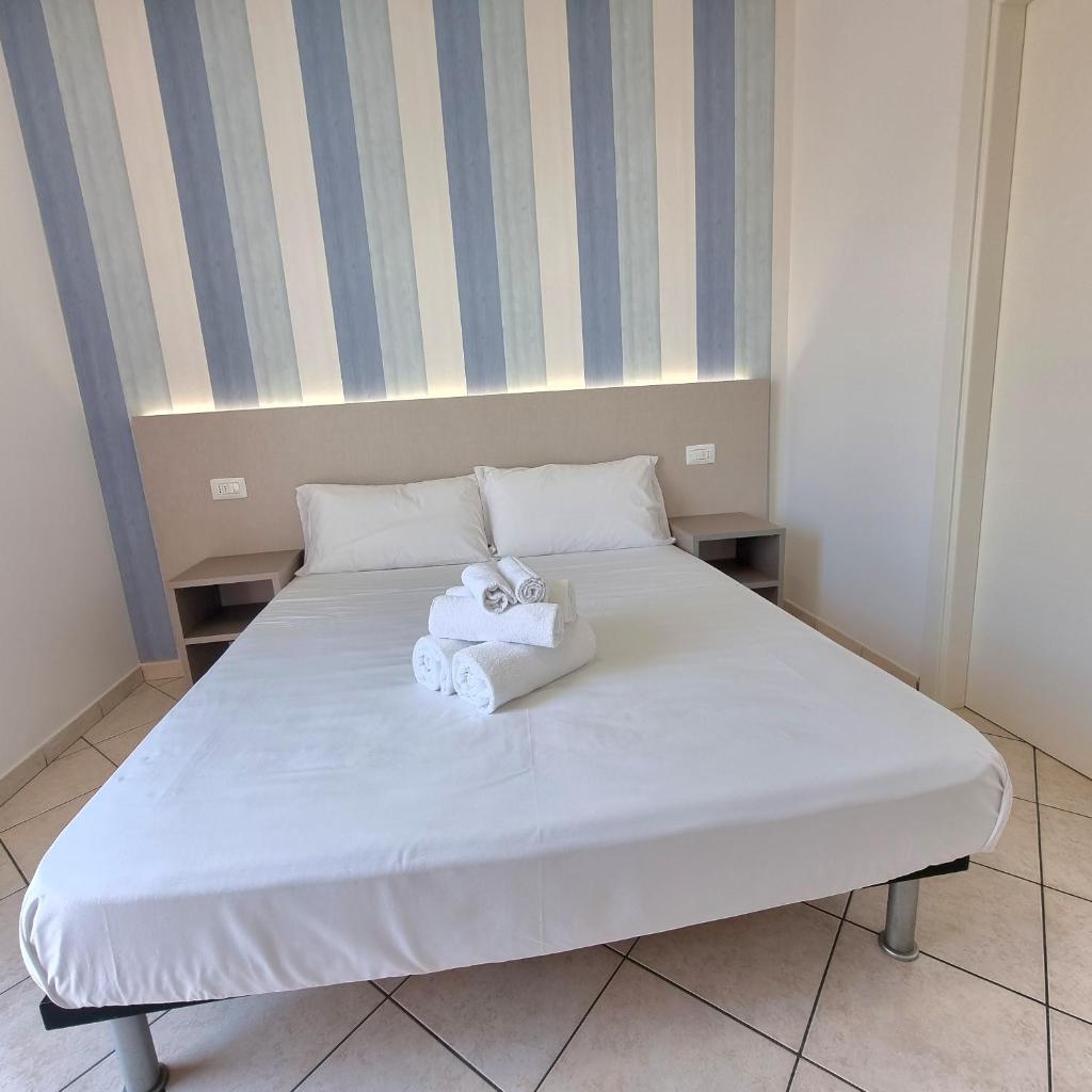 un lit blanc avec deux serviettes dessus dans l'établissement Residence Mare, à Rimini
