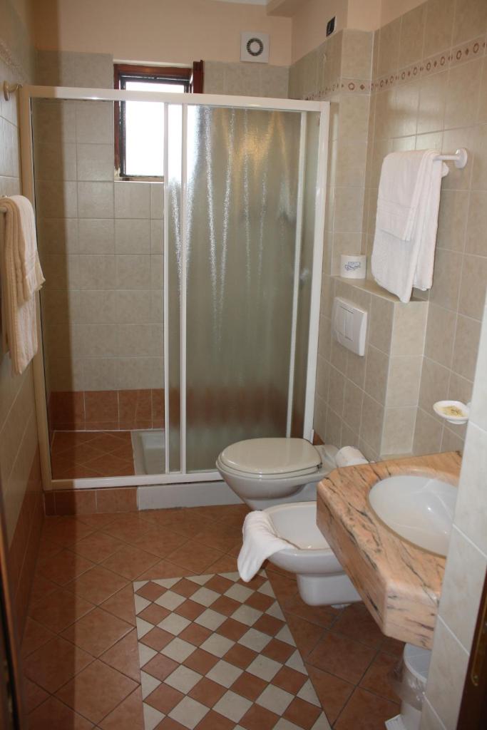 une salle de bain avec toilettes, douche et lavabo dans l'établissement Albergo Ristorante Punta Dell'Est, à Clusane