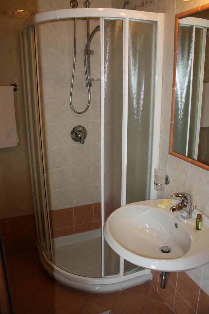une salle de bain avec douche et lavabo dans l'établissement Albergo Ristorante Punta Dell'Est, à Clusane