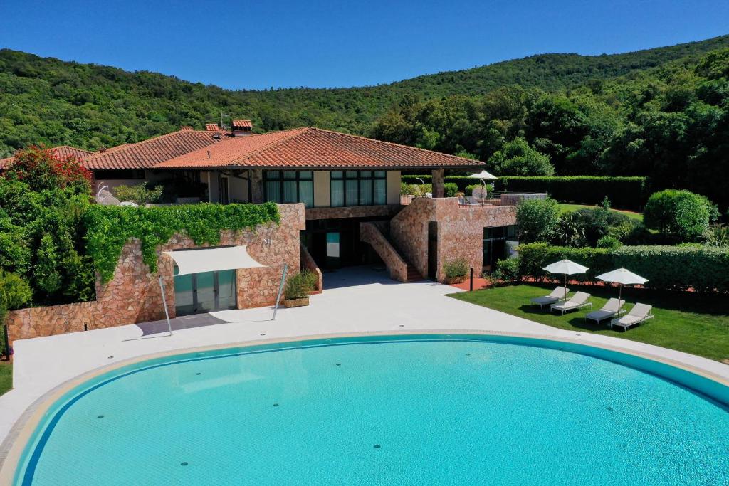 une villa avec piscine devant une maison dans l'établissement Argentario Lagoon Resort & Spa, à Monte Argentario