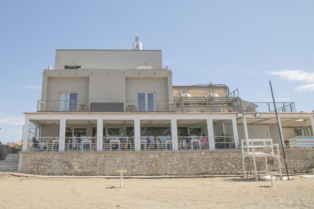 - un bâtiment sur la plage à côté d'une plage dans l'établissement Hotel Villa Ambra, à Orbetello