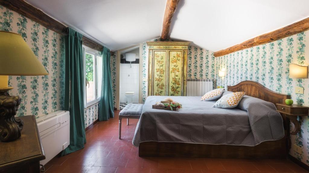 une chambre avec un lit avec du papier peint bleu et vert dans l'établissement CASALE DELL'OASI 12, Emma Villas, à Gallese