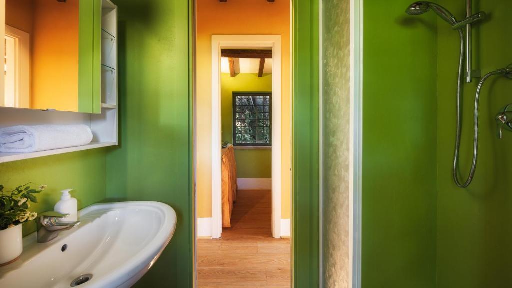 une salle de bain avec des murs verts et oranges et un lavabo dans l'établissement CASALE DELL'OASI 12, Emma Villas, à Gallese 50 autres photos