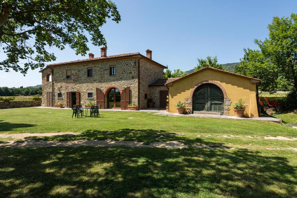 une vieille maison en pierre avec une grande cour dans l'établissement Villa la Ghiandaia by Mmega, à Pergognano