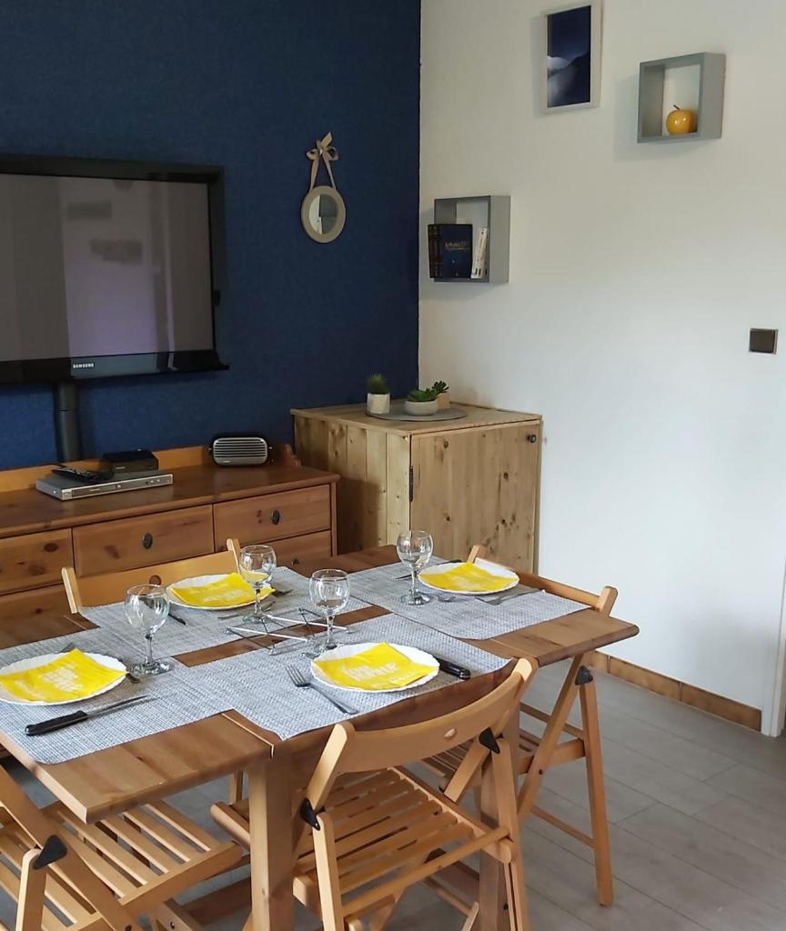 une table en bois avec des assiettes et des verres à vin dessus dans l'établissement Beautiful studio with balcony in Briançon, à Briançon