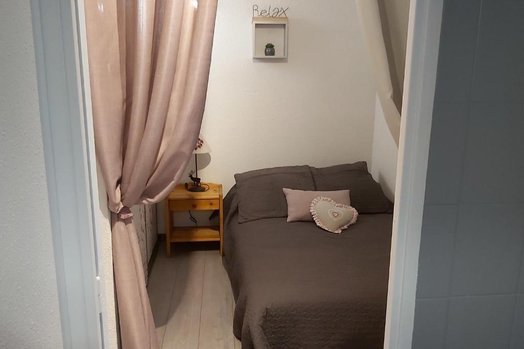 une petite chambre avec un lit et une fenêtre dans l'établissement Beautiful studio with balcony in Briançon, à Briançon 4 autres photos