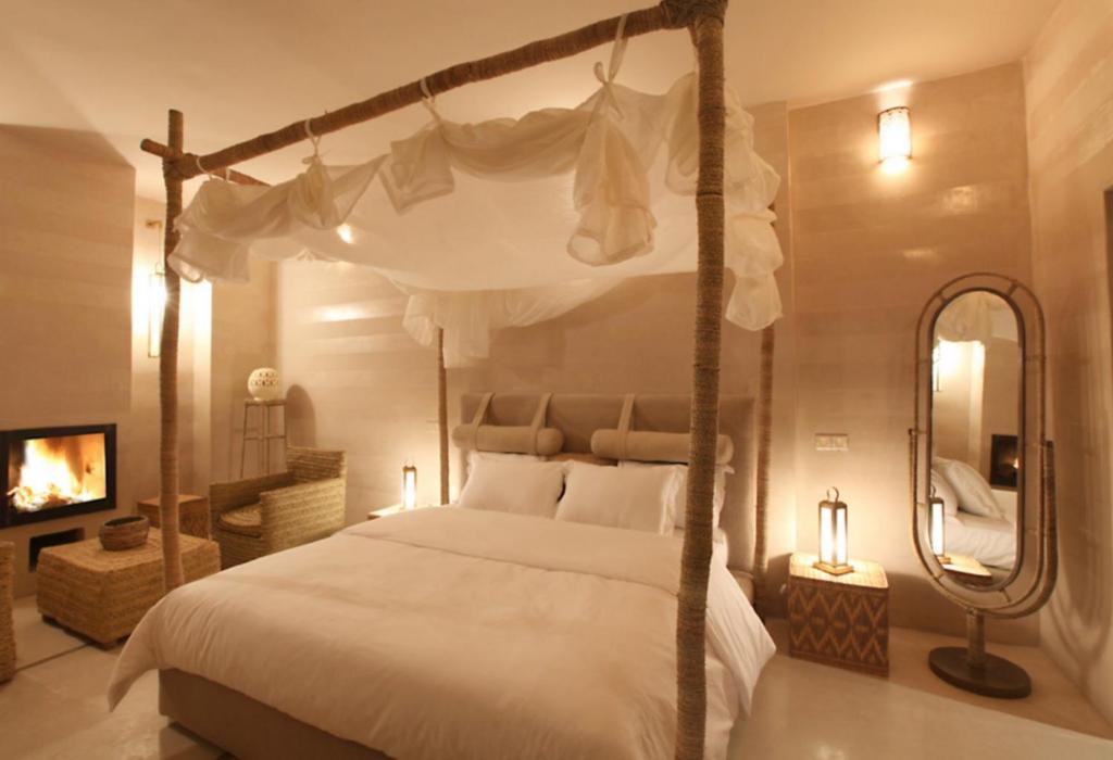 une chambre avec un lit à baldaquin et un miroir dans l'établissement Riad Joya, à Marrakech 31 autres photos