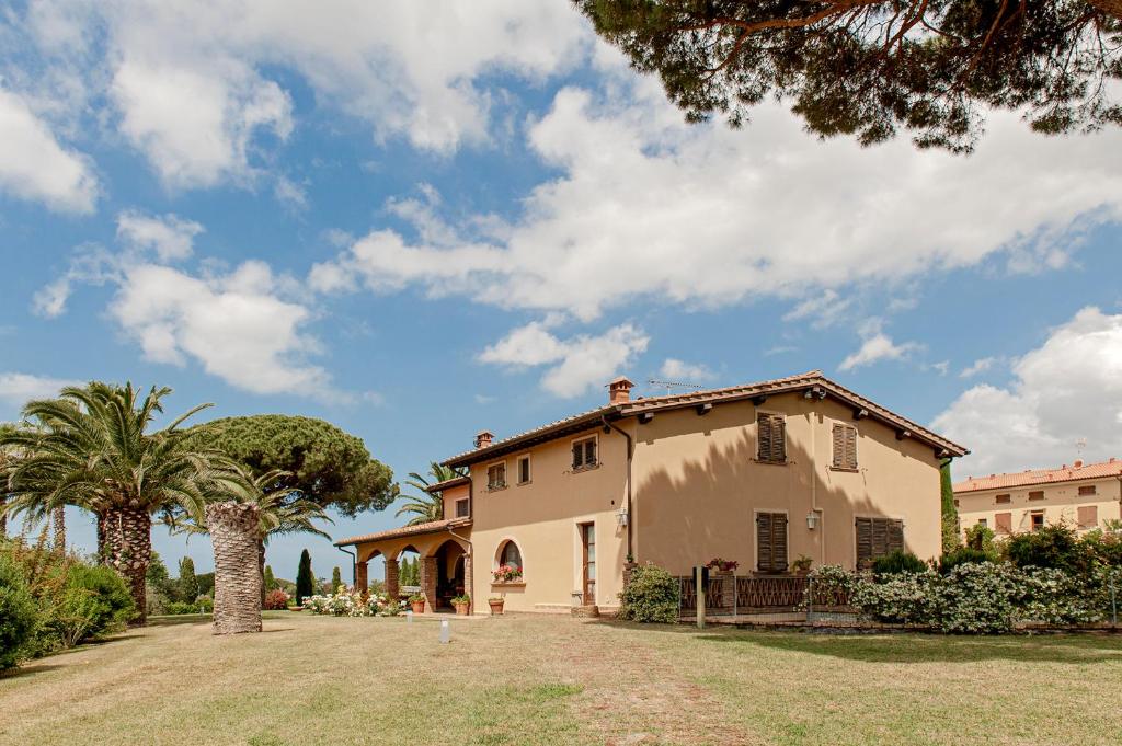 une maison avec un palmier et une cour dans l'établissement Villa delle Palme, à Cecina