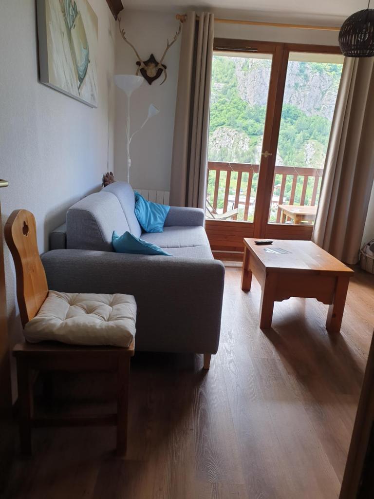 un salon avec un canapé et une table basse dans l'établissement T2 Les Chardons avec Piscine Sauna et Hammam, à Valloire