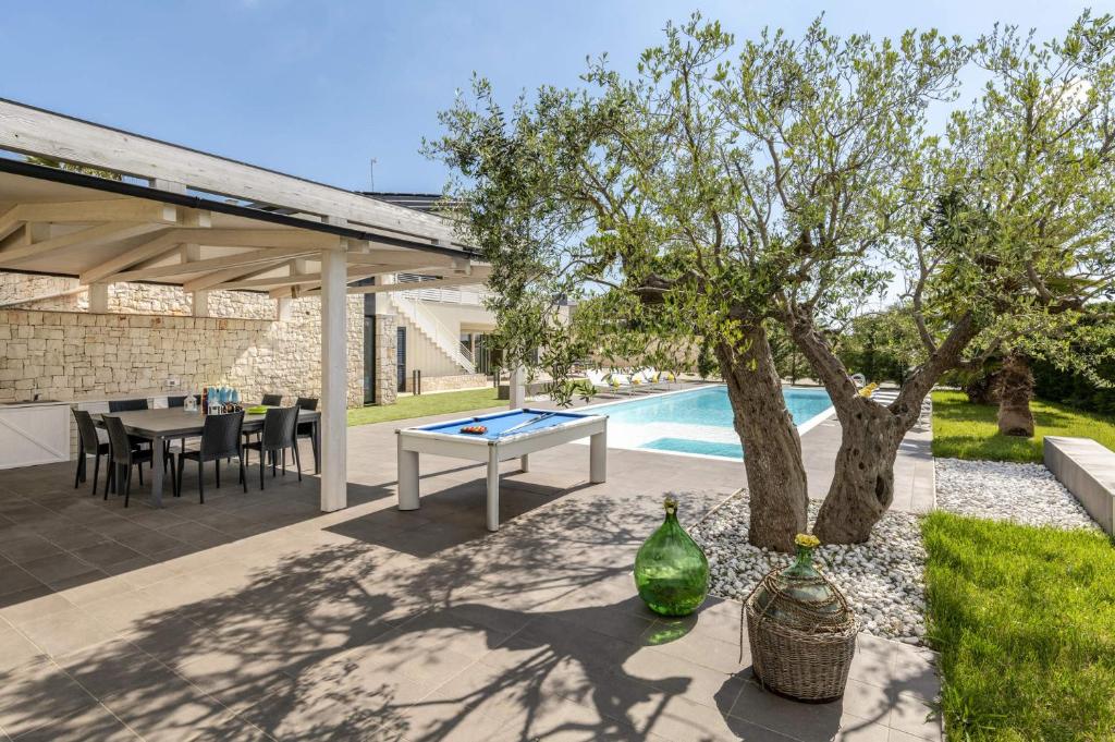 une terrasse avec une table de ping-pong et un arbre dans l'établissement Villa Campanella by Villa Plus, à Noci 18 autres photos