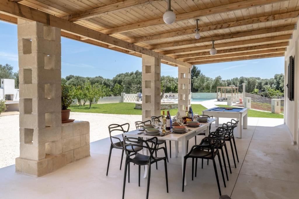 - un coin repas extérieur avec une table et des chaises dans l'établissement Villa Trullo Lofino by Villa Plus, à Carovigno