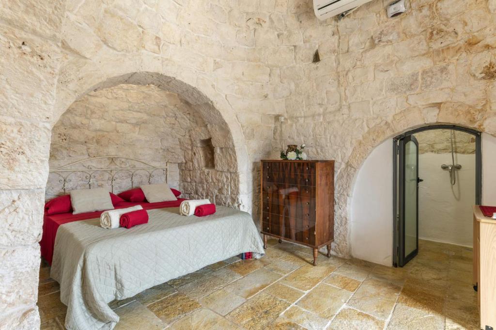 une chambre avec un lit dans un mur de pierre dans l'établissement Villa Trullo Lofino by Villa Plus, à Carovigno