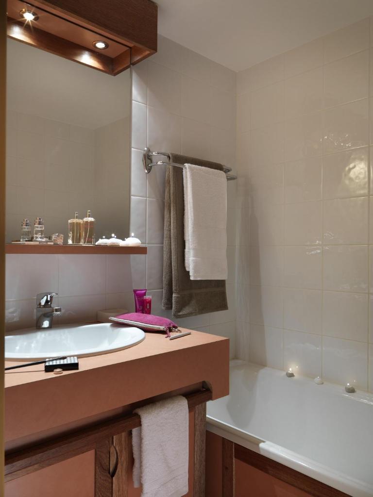 une salle de bain avec une baignoire et un lavabo et une baignoire dans l'établissement Résidence Odalys Tourotel, à Val Thorens 37 autres photos
