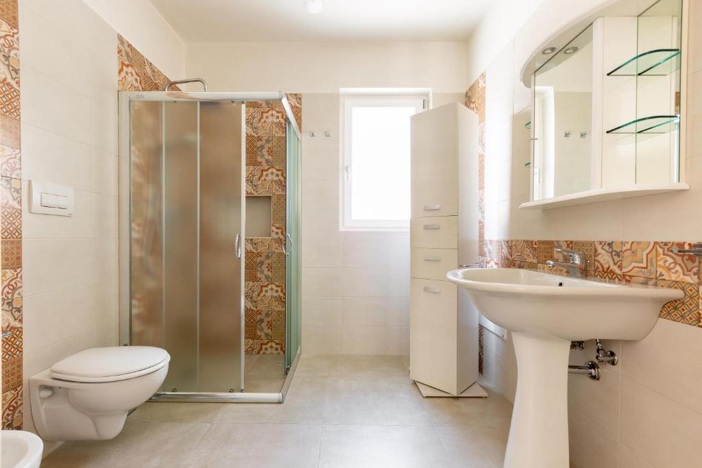 une salle de bain avec toilettes, lavabo et douche dans l'établissement Villa La Seta by Perle di Puglia, à San Vito dei Normanni