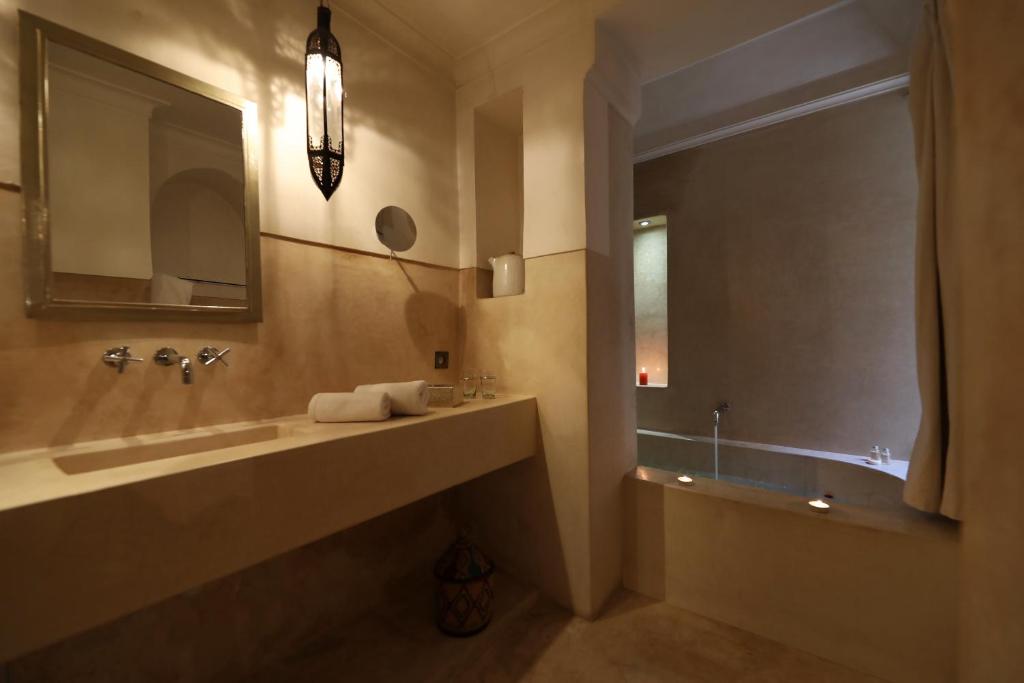 une salle de bain avec un grand lavabo et un miroir dans l'établissement Dar Akal, à Marrakech