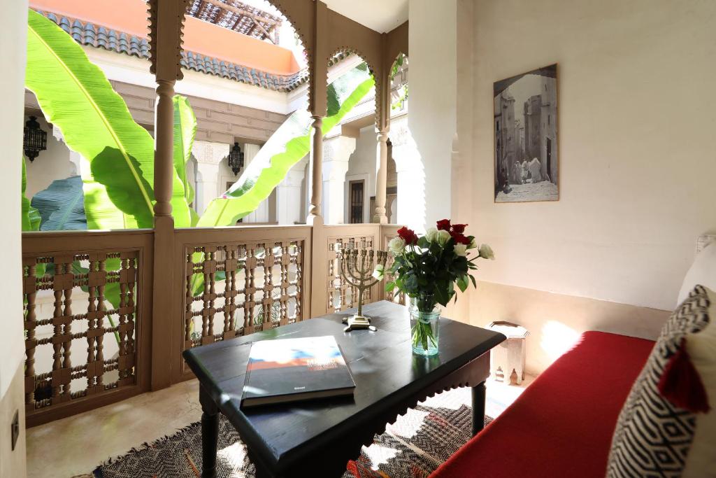 une chambre avec une table et un vase de fleurs dans l'établissement Dar Akal, à Marrakech