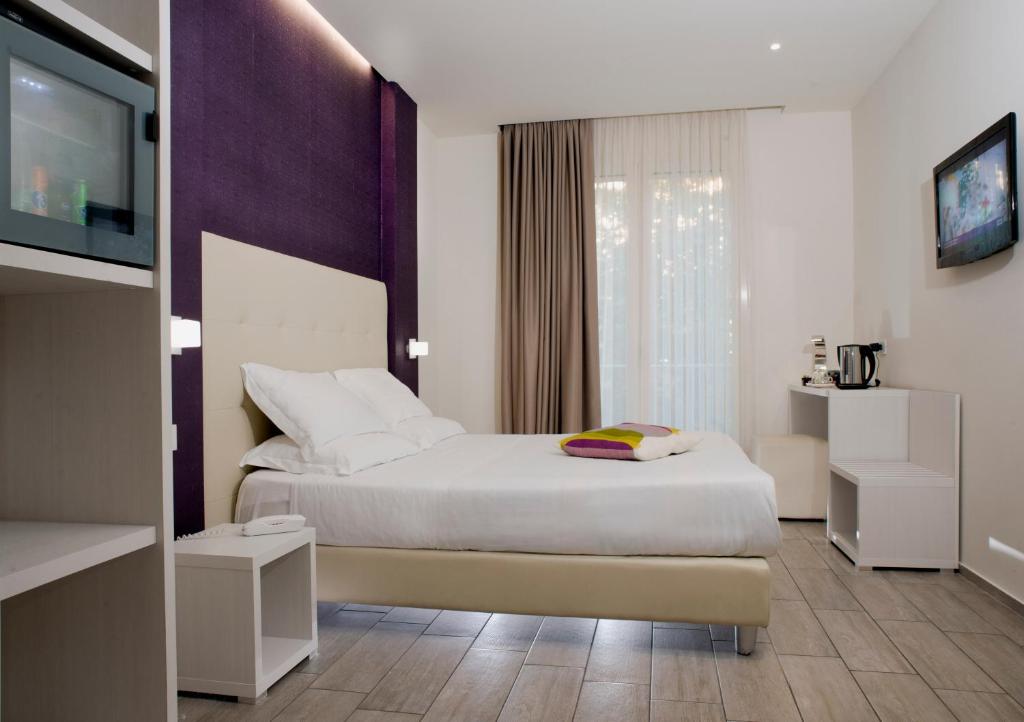 une chambre d'hôtel avec un lit et une télévision à écran plat dans l'établissement L'Hotel, à Rimini 48 autres photos