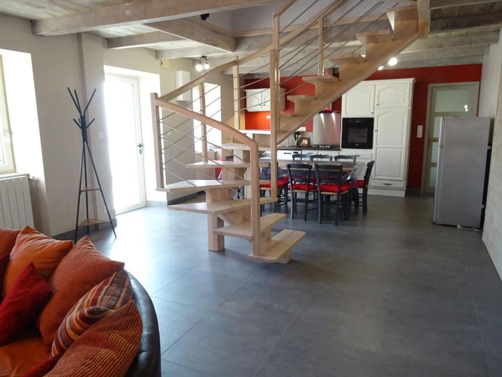 un salon avec un escalier en colimaçon et une cuisine dans l'établissement Gîte Les Paredous, à Broquiès