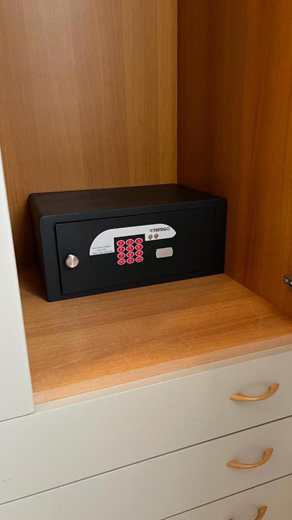 une horloge noire assise sur une commode dans l'établissement chiAma Hotel, à Rimini