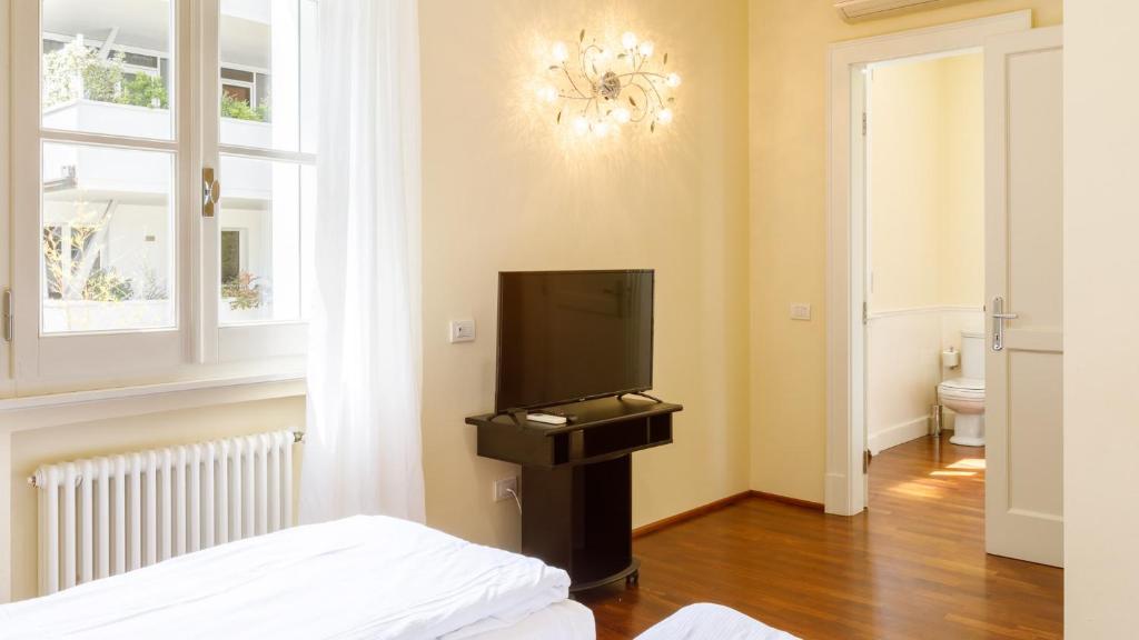 - une chambre avec une télévision, un lit et une fenêtre dans l'établissement Villa Guidi 10 Emma Villas, à Milano Marittima