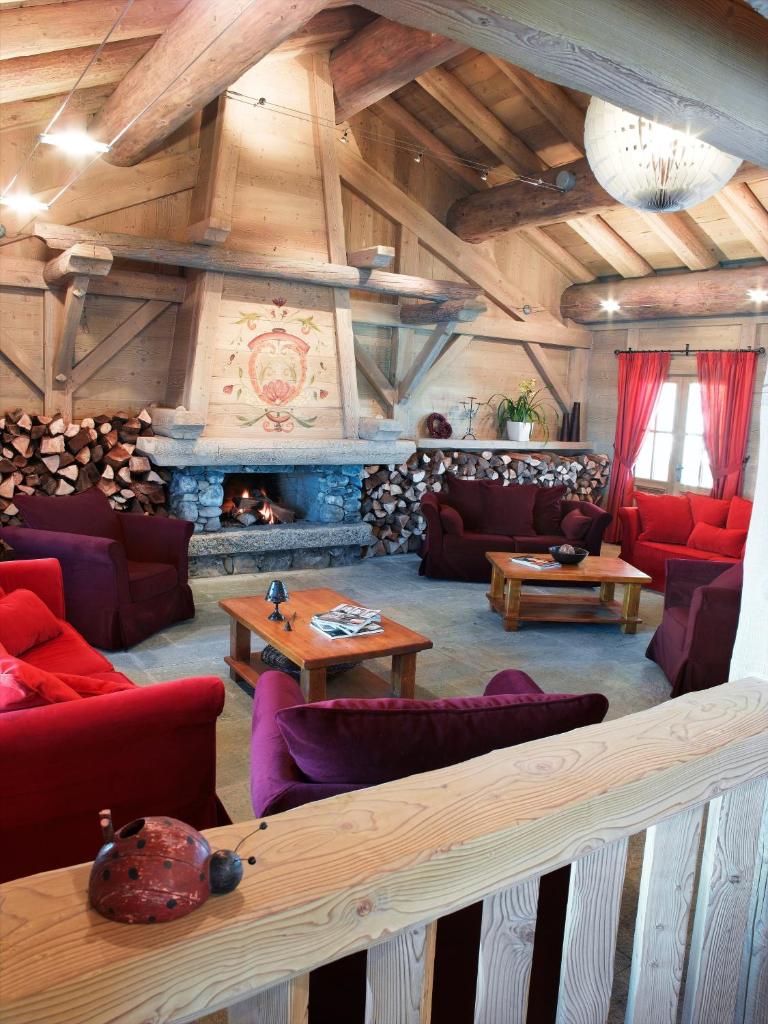 un salon avec des meubles rouges et une cheminée dans l'établissement CGH Résidences & Spas Le Hameau Du Beaufortain, aux Saisies