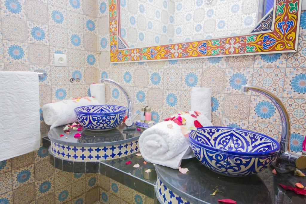 La salle de bains est pourvue de 2 lavabos bleus et blancs et d'un miroir. dans l'établissement Riad Mahrez, à Fès 37 autres photos