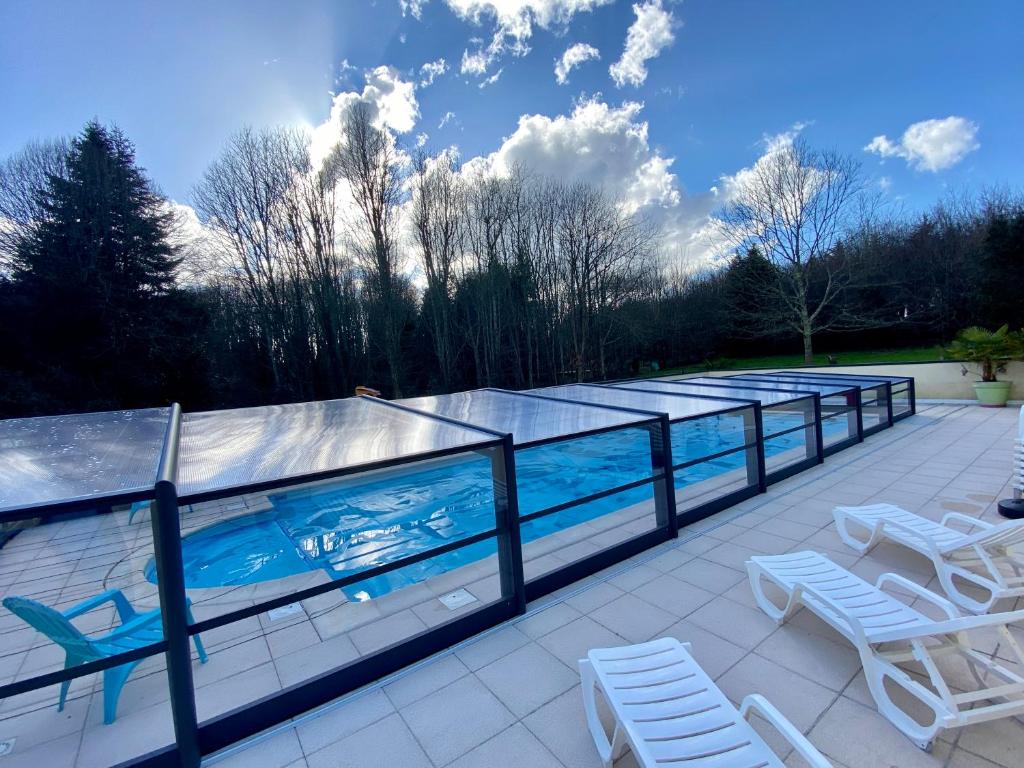 - une piscine avec 2 chaises longues et 2 chaises dans l'établissement Dôme S'féérique avec accès piscine, à Saint-Évarzec