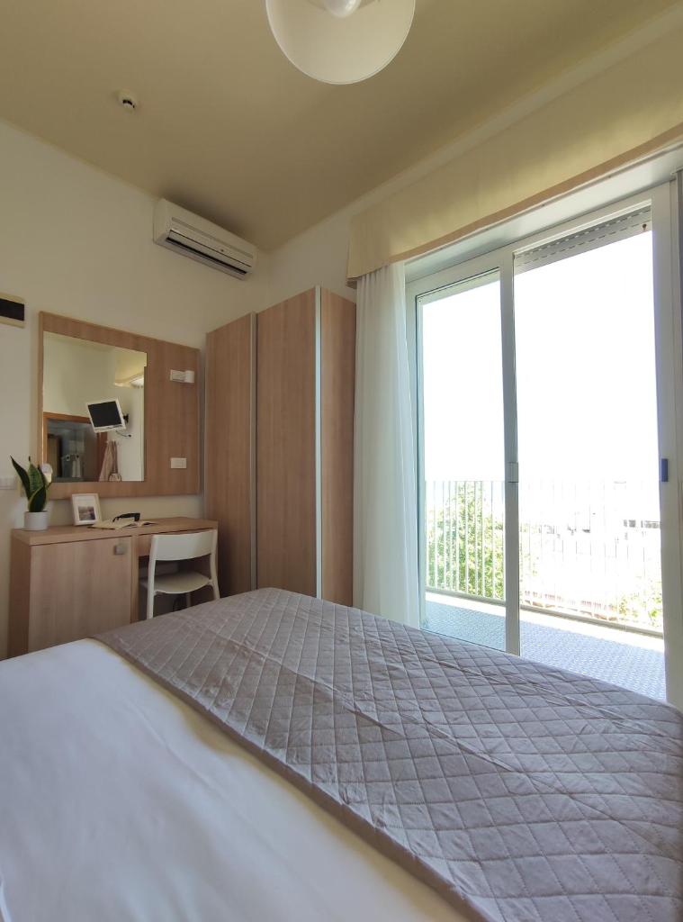 une chambre avec un grand lit et une grande fenêtre dans l'établissement Hotel Galassia, à Rimini